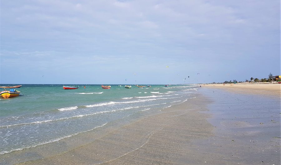 Plage de sable de la Praia do Preá à Cruz, dans l’État brésilien du Ceará, avec des bateaux et des cerfs-volants de kitesurf en arrière-plan