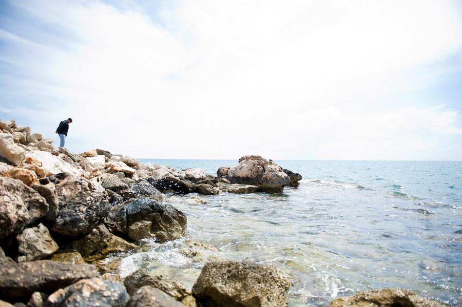 Un visiteur marche le long des rochers au bord de la côte méditerranéenne dans la province de Mersin, en Turquie