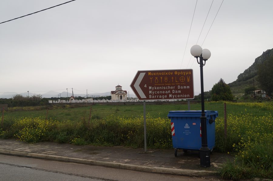 Panneau indicateur à Nea Tiryntha vers la digue de Tirynthe avec des signes en écriture linéaire B