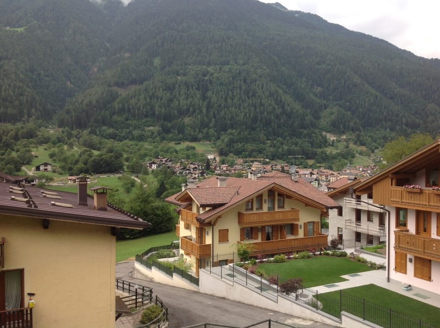 Panorama de Bocenago vu depuis le balcon d’un appartement, avec les montagnes du Val Rendena en arrière-plan.