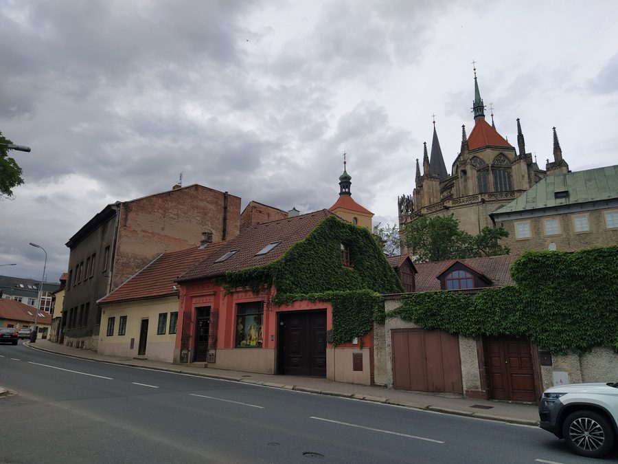 Église Saint-Barthélemy entre des maisons historiques à Kolín