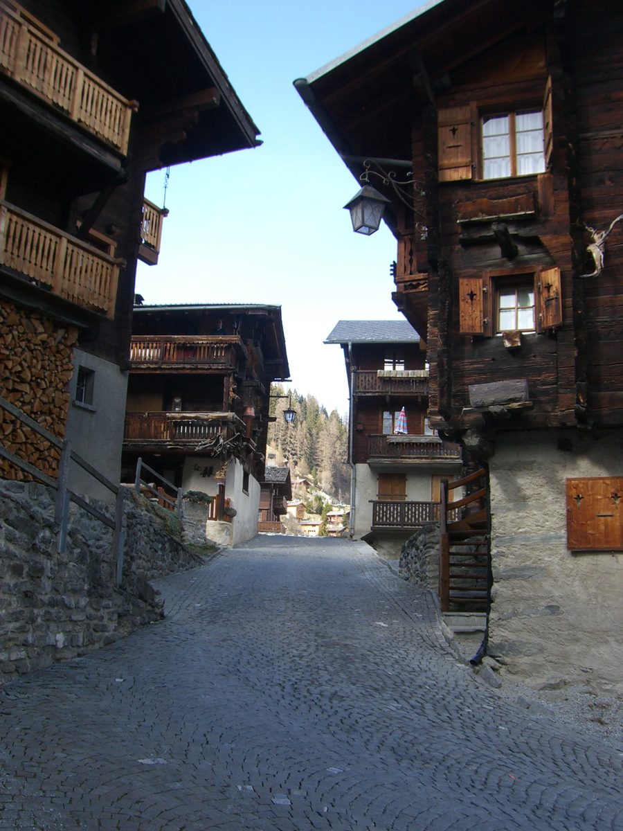 Ruelle historique étroite avec des maisons traditionnelles en bois à Grimentz en Valais